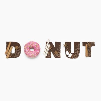 Creative concept photo of  a donut sign made of sugar and coffee beans on white background.