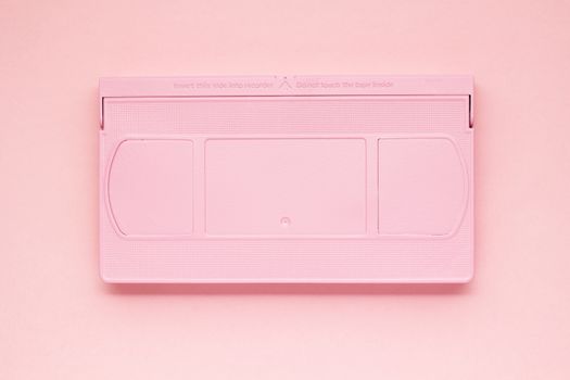 Creative photo of  painted VHS cassette on pink  background.