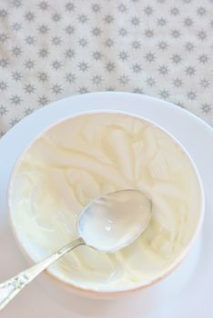 empty ceramic bowl of white yoghurt and spoon