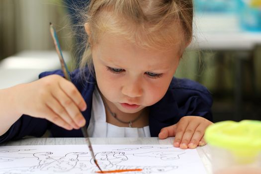 Cute little girl painting watercolors