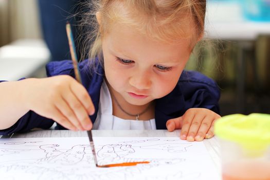 Cute little girl painting watercolors