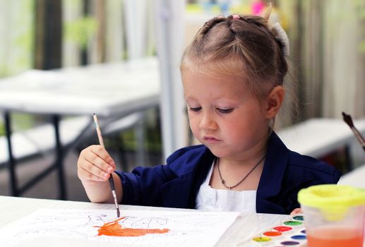 Cute little girl painting watercolors