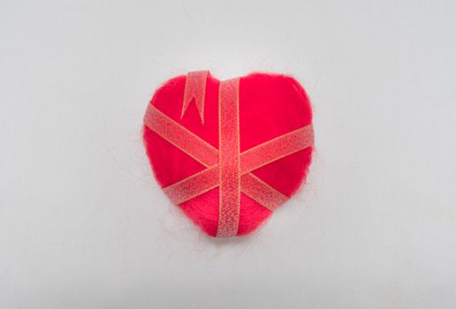 Ribbon wrapped heart on wood background