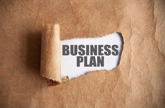 Torn piece of scroll uncovering business plan underneath