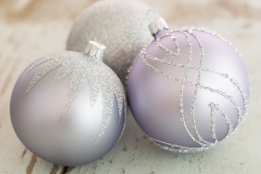 Decorated silver Christmas baubles with focus to a single bauble in the foreground to celebrate Xmas and the festive holiday season