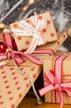 Close-up composition of Christmas present boxes of kraft paper with ribbons, decorations and stars pattern