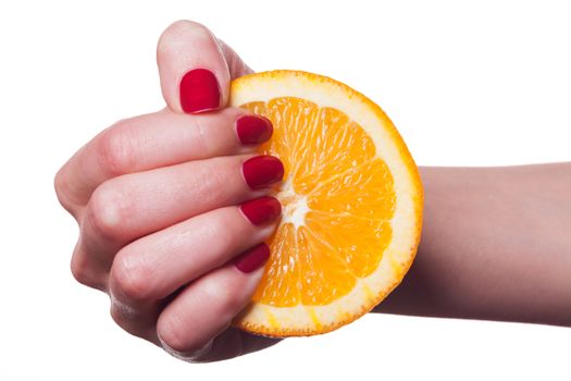 Hand with manicured nails painted a deep glossy red touch an orange on white background