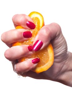 Hand with manicured nails painted a deep glossy red touch an orange on white background