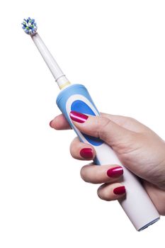 Hand with manicure holds single blue electric toothbrush against white background