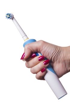 Hand with manicure holds single blue electric toothbrush against white background