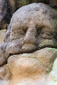 Rock relief - detail of the head of angel.
Stone altar carved in sandstone cliff in the forest near the village Marenicky, Lusatian Mountains, Czech Republic.
Stone altar carved into the sandstone - detail of the head of a praying angel