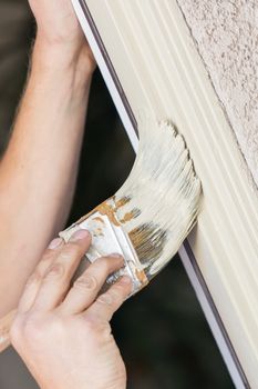 Professional Painter Cutting In With A Brush to Paint House Door Frame.