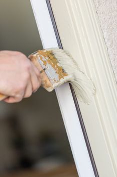 Professional Painter Cutting In With A Brush to Paint House Door Frame.