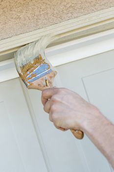 Professional Painter Cutting In With A Brush to Paint Garage Door Frame.