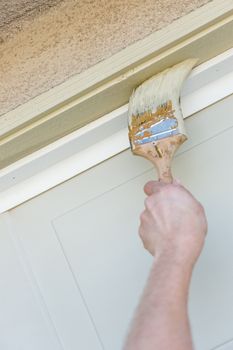 Professional Painter Cutting In With A Brush to Paint Garage Door Frame.