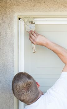 Professional Painter Cutting In With A Brush to Paint Garage Door Frame.