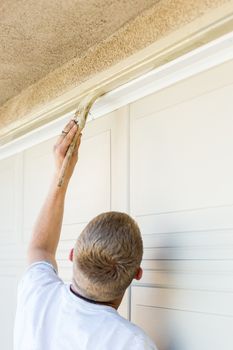 Professional Painter Cutting In With A Brush to Paint Garage Door Frame.
