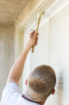 Professional Painter Cutting In With A Brush to Paint Garage Door Frame.