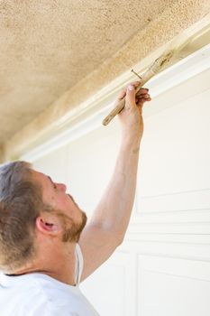 Professional Painter Cutting In With A Brush to Paint Garage Door Frame.