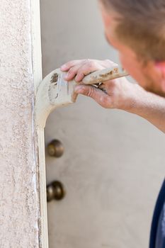 Professional Painter Cutting In With A Brush to Paint House Door Frame.