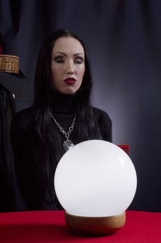 Fortune teller with a magic ball on a black background