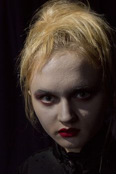 Young girl vampire on a black background