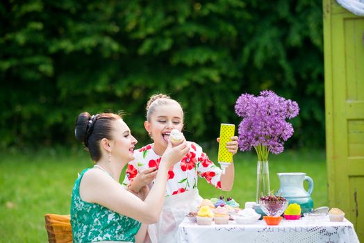 mother with daughter have a breakfast in the garden