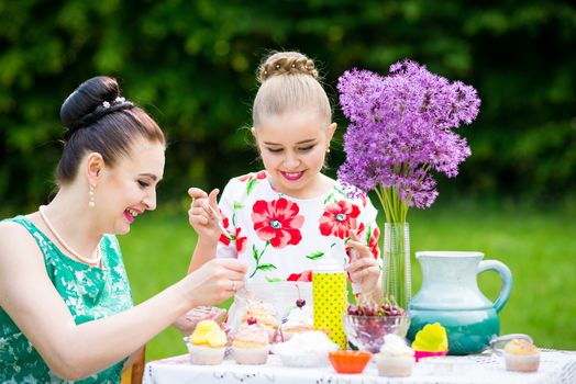 mother with daughter have a breakfast in the garden