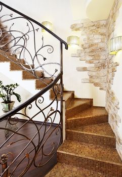 Classical mosaic stairs with ornamental handrail in hallway with stone decors