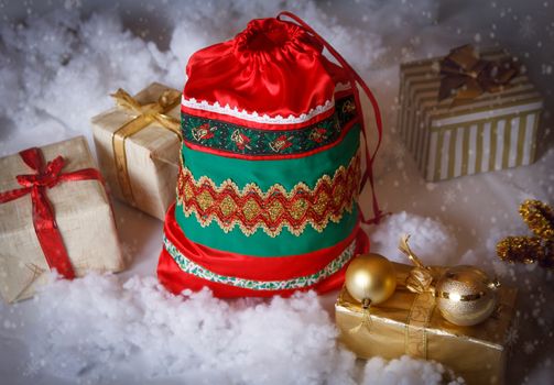 Santa Claus red bag with Christmas gifts on snowy back
