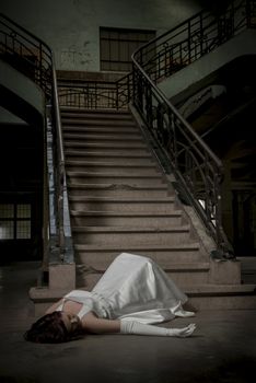 bride's fallen down the stairs by accident and lies unconscious on the ground