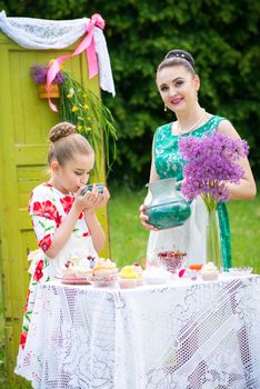 mother with daughter have a breakfast in the garden