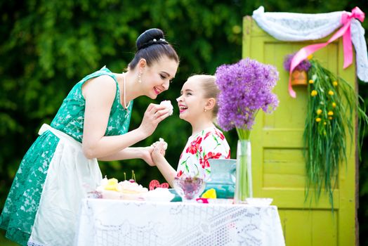 mother with daughter have a breakfast in the garden