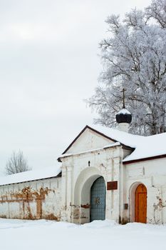 White winter trees and doorway in big wall in Uglich
