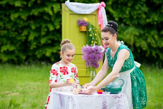 mother with daughter have a breakfast in the garden