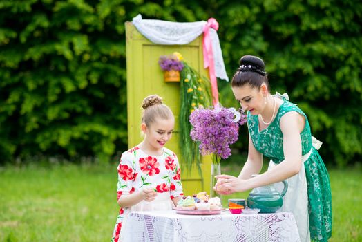 mother with daughter have a breakfast in the garden