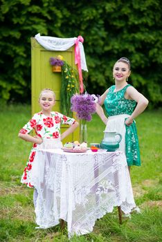 mother with daughter have a breakfast in the garden