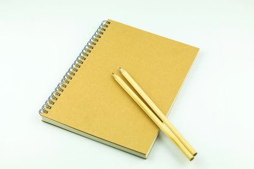 close notebook with pencil on white background