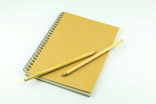 close notebook with pencil on white background