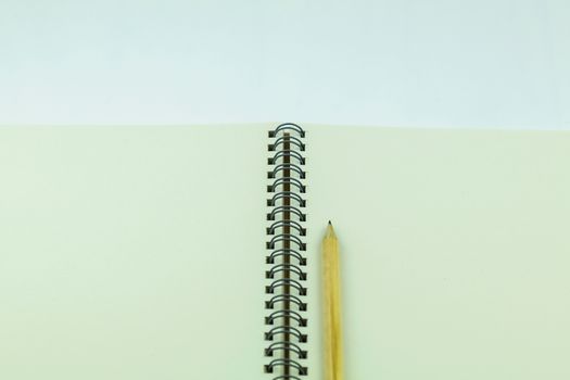 open notebook with pencil on white background