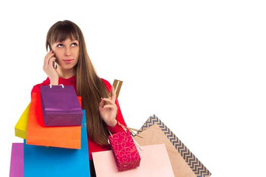 Young woman with banking credit card, colourful shopping paper bags and packages, smartphone