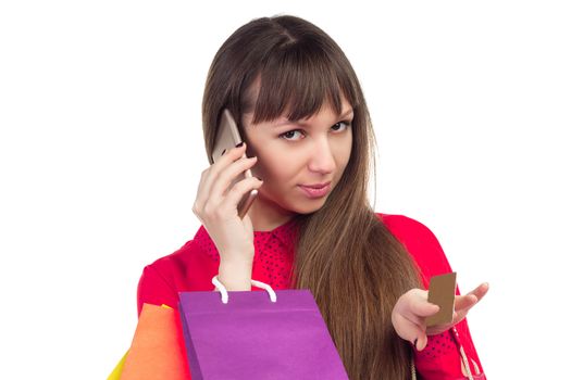 Young woman with banking credit card, colourful shopping paper bags and packages, smartphone