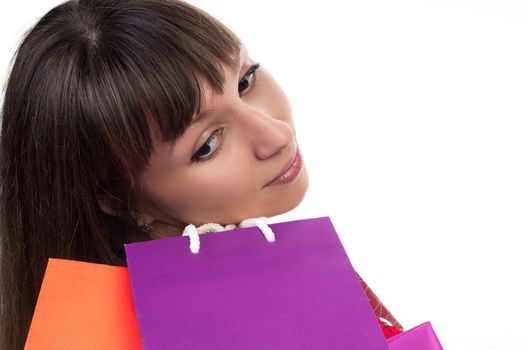 Close-up of smiling young woman face with colourful shopping paper bags