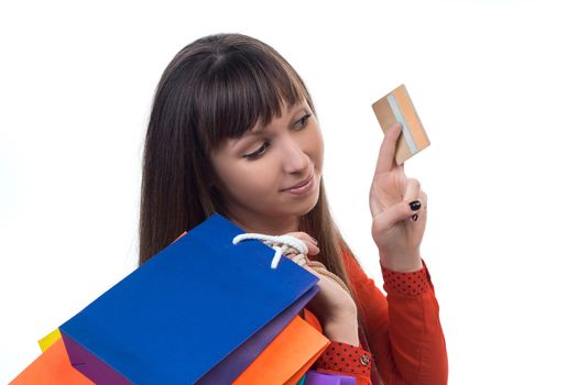 Young woman shopping with credit card holding colourful paper bags and packages
