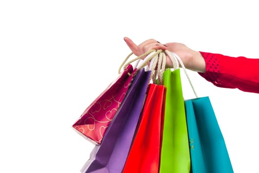 Colourful and bright shopping paper packages hanging on female red-sleeved arm