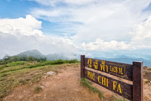Nameplate attractions viewpoint and blue sky with white cloud above high mountain at Phu Chi Fa Forest Park in Chiang Rai Province Thailand