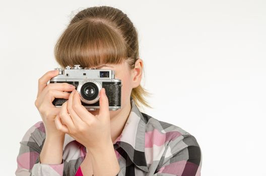 The girl photographer photographing the old film camera