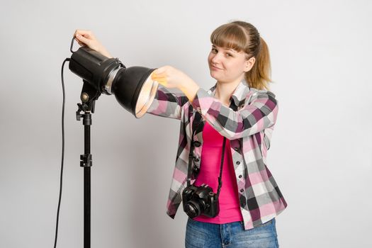Photographer studio sets reflector on monoblock flash