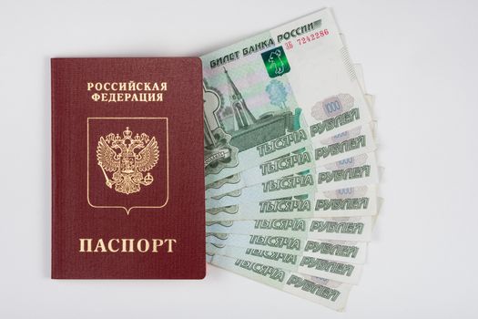 Passport and money fanned out on a white background