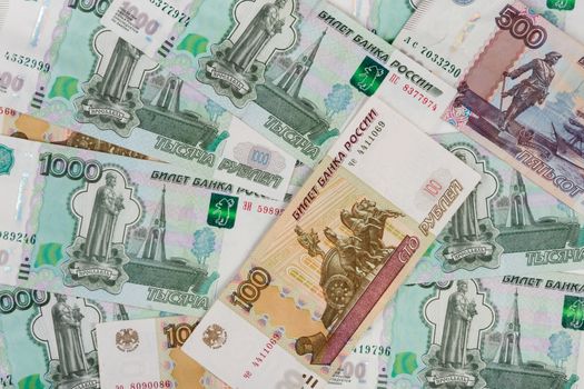 The background of randomly scattered Russian banknotes of different denomination